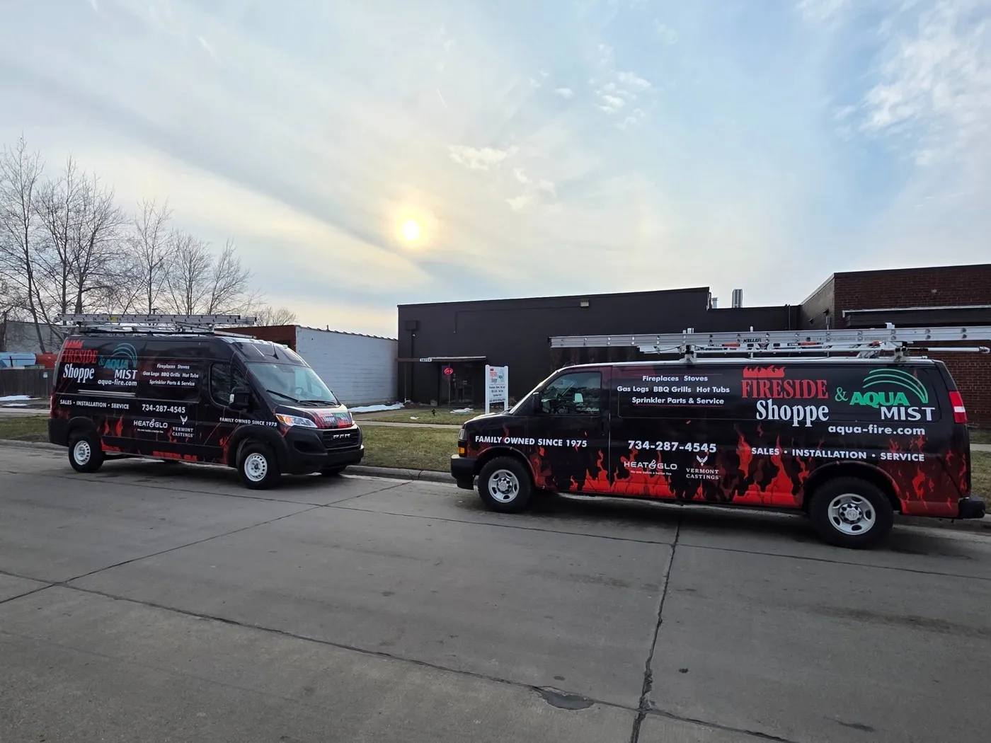The two Fireside Shoppe & Aqua Mist wrapped service vans parked outside the Riverview shop