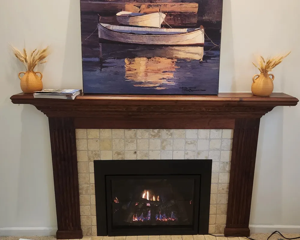 A lit insert under a warm wood mantel