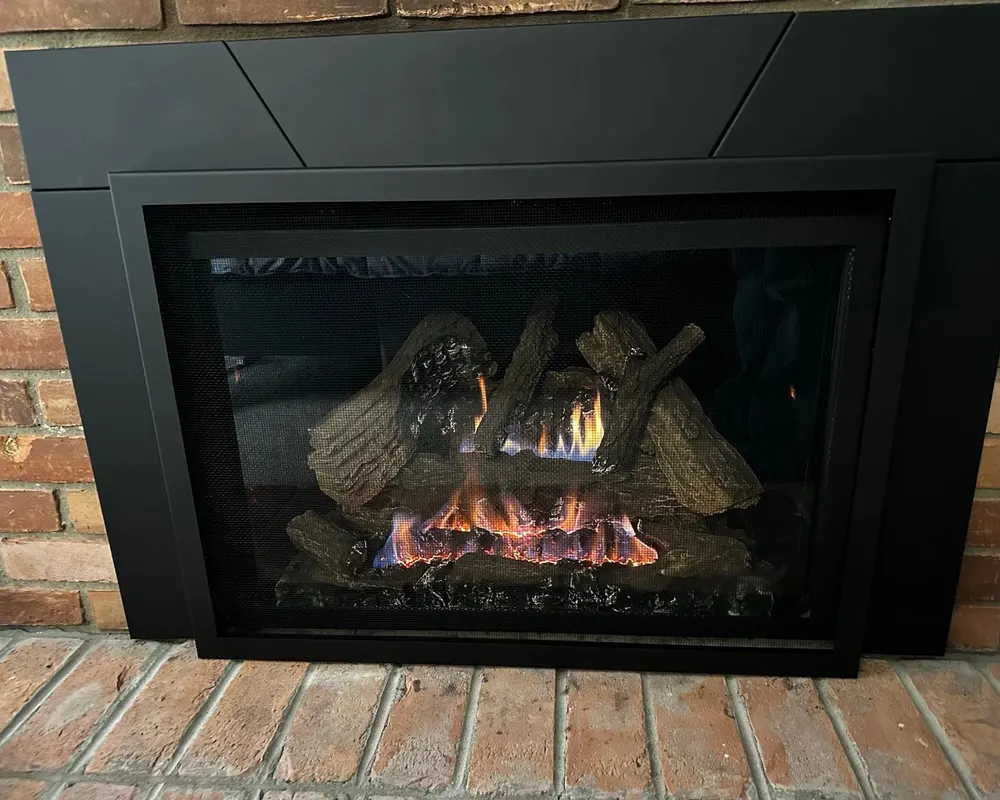 A gas insert with a full log set on red brick