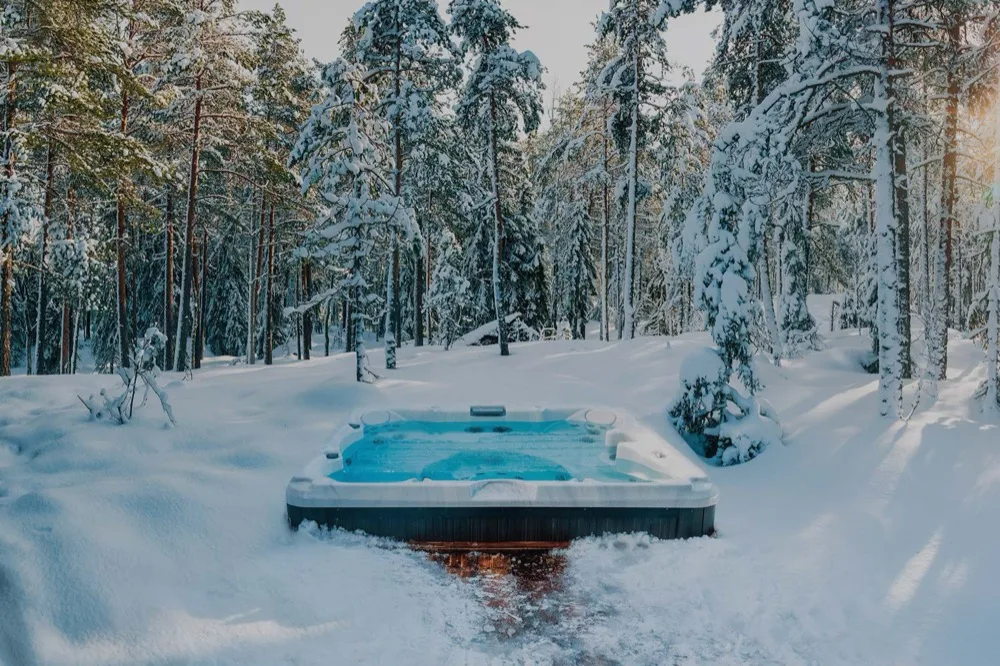 A Thermēa hot tub steaming on a snowy patio